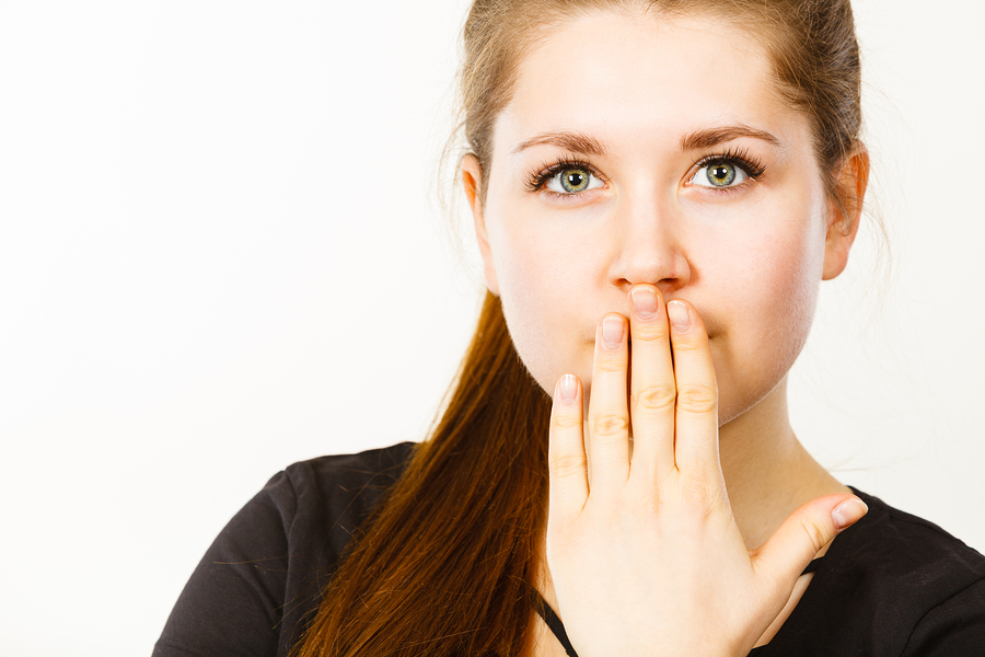 Woman covering her mouth with hand. 
