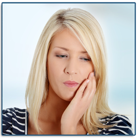 A blonde woman hodling her left cheek and jaw in pain