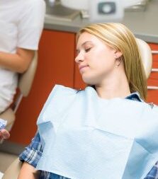 Woman asleep in dental chair from dental sedation